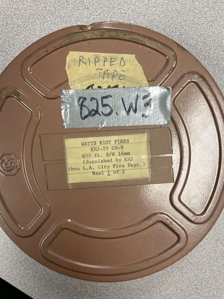 Collections Assessment for Preservation at the Disaster Research Center Watts riot fire reel can showing a significant dent at the top.